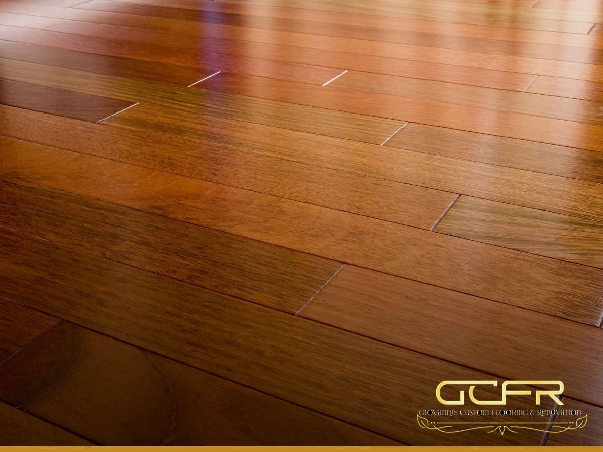 Shiny hardwood floors with varying shades of warm brown tones, professionally installed with visible joints